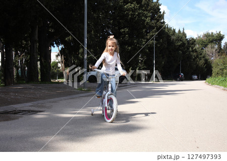 little cute girl riding a bicycle in green park, lifestyle people concept 127497393