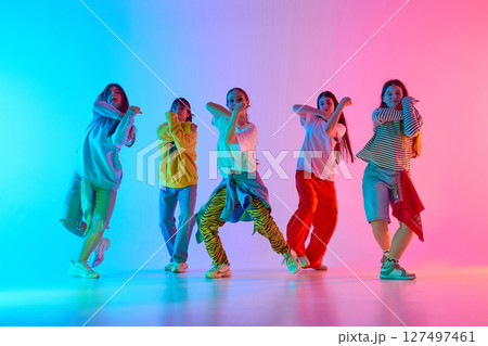 Urban dance group showcasing vibrant youthful energy and creative expression under colorful lighting Urban dance group showcasing vibrant youthful energy and creative expression under colorful lighting 127497461