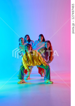 Youthful urban dancers radiating vibrant energy and dynamic team spirit in colorful studio backdrop Youthful urban dancers radiating vibrant energy and dynamic team spirit in colorful studio backdrop 127497465