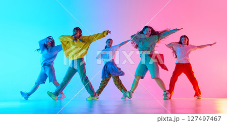 Youthful dancers showcase vibrant urban style with dynamic poses and colorful background lighting Youthful dancers showcase vibrant urban style with dynamic poses and colorful background lighting 127497467