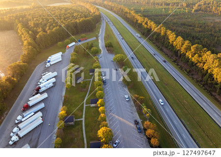Large truck stop with resting area near busy American interstate freeway. Parking place during big rig interstate travel 127497647