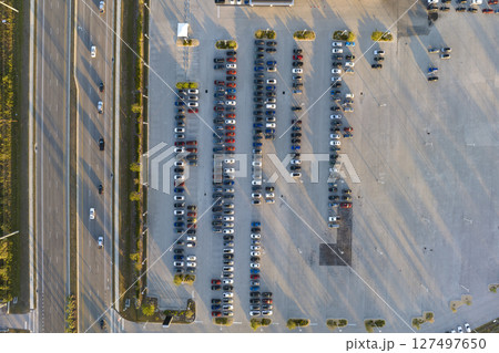 Large parking lot of local dealer with many brand new cars parked for sale on highway roadside. Development of american automotive industry and distribution of manufactured vehicles concept 127497650