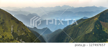 Landscape view of green majestic Carpathian mountains covered with light mist in dawn. Landscape view of green majestic Carpathian mountains covered with light mist in dawn. 127497657