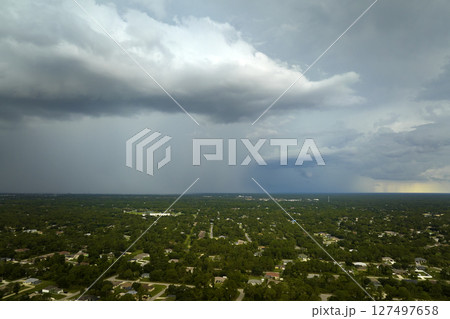 Landscape of dark ominous clouds forming on stormy sky during heavy thunderstorm over rural town area Landscape of dark ominous clouds forming on stormy sky during heavy thunderstorm over rural town area 127497658