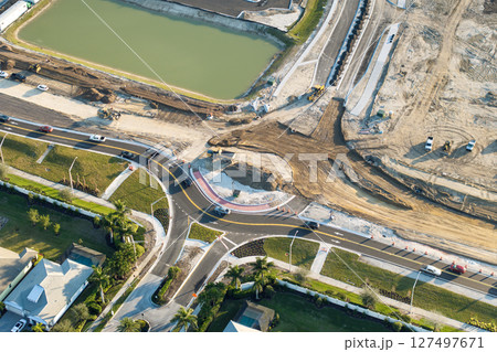 Industrial roadworks. Roundabout on wide American highway under construction. Development of transportation system for rapid transit Industrial roadworks. Roundabout on wide American highway under construction. Development of transportation system for rapid transit 127497671