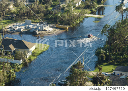 Hurricahe fainfall flooded Florida road with evacuating cars and surrounded with water houses in suburban residential area Hurricahe fainfall flooded Florida road with evacuating cars and surrounded with water houses in suburban residential area 127497720