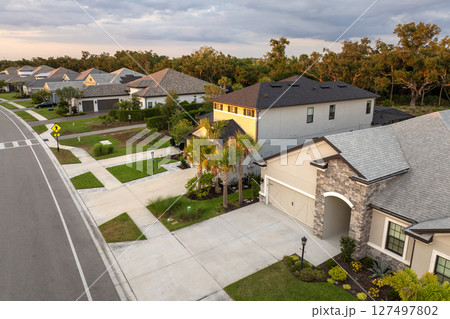 Gated community with expensive houses between green palm trees in southwest Florida. Premium housing development in the USA Gated community with expensive houses between green palm trees in southwest Florida. Premium housing development in the USA 127497802