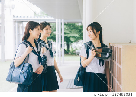 下駄箱の前で挨拶をする女子高生 127498031