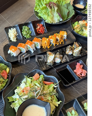 Sushi salad platters Japanese sushi kaiseki fine dining platter combo set on the wooden board with vegetable display 127498582