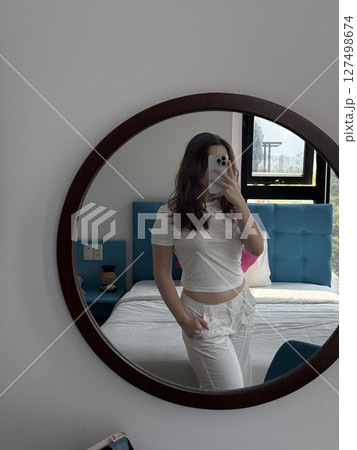 vertical photos Mirror reflection selfie Woman Trying on Outfit Taking a Selfie in a Changing Room Mirror. Funny girl checking her new clothes while posting on social media vertical photos Mirror reflection selfie Woman Trying on Outfit Taking a Selfie in a Changing Room Mirror. Funny girl checking her new clothes while posting on social media 127498674