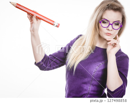 Woman confused thinking, big pencil in hand 127498858