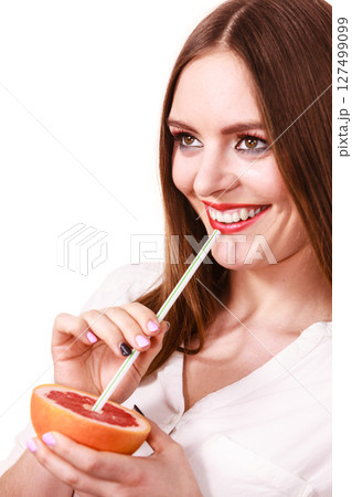 Woman holds grapefruit drinking juice from fruit 127499099