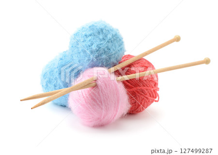 Multicolored balls of woolen threads and wooden knitting needles isolated on white Multicolored balls of woolen threads and wooden knitting needles isolated on white 127499287