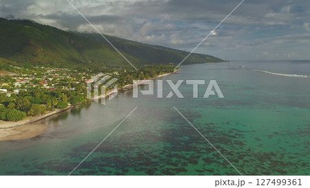 Stunning drone footage captures the idyllic beauty of huahine, French Polynesia, featuring crystal-clear turquoise waters lapping against a lush coastline by vibrant mountains 127499361
