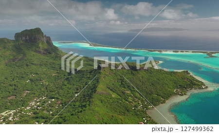 Breathtaking beauty of Bora Bora tropical island, green mountain vegetation, vibrant turquoise lagoon, dramatic volcanic peaks under cloudy sky. Wild travel destination, remote nature paradise. Aerial Breathtaking beauty of Bora Bora tropical island, green mountain vegetation, vibrant turquoise lagoon, dramatic volcanic peaks under cloudy sky. Wild travel destination, remote nature paradise. Aerial 127499362