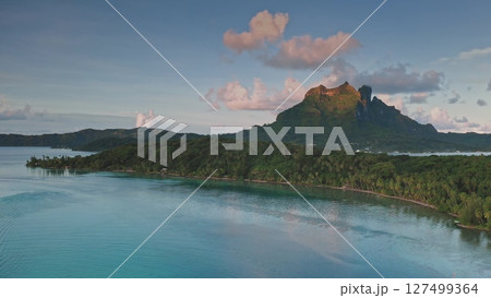 Aerial drone view of mount Otemanu in Bora Bora. French Polynesia. Reflecting in the calm turquoise lagoon at sunset. With lush vegetation in the foreground and a beautiful pink and purple cloudscape Aerial drone view of mount Otemanu in Bora Bora. French Polynesia. Reflecting in the calm turquoise lagoon at sunset. With lush vegetation in the foreground and a beautiful pink and purple cloudscape 127499364