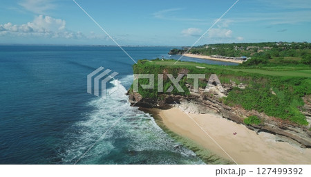 Stunning aerial view of Pantai Dreamland Beach in Bali, Indonesia, featuring turquoise waters, white sands, lush cliffs, and crashing waves in a tropical paradise Stunning aerial view of Pantai Dreamland Beach in Bali, Indonesia, featuring turquoise waters, white sands, lush cliffs, and crashing waves in a tropical paradise 127499392