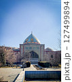 Historic Persian mosque in Erevan Armenia with intricate tilework, golden dome, and archway, surrounded by bare trees under clear blue sky in a peaceful courtyard setting 127499894