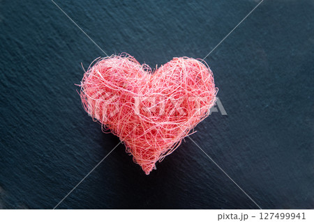 Heart shape made of material fabric on the black background with copyspace. Concept of Valentine's day and romantic love. Heart shape made of material fabric on the black background with copyspace. Concept of Valentine's day and romantic love. 127499941