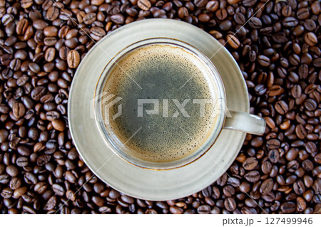 Green cup of coffee and roasted coffee beans background. Top view. Green cup of coffee and roasted coffee beans background. Top view. 127499946
