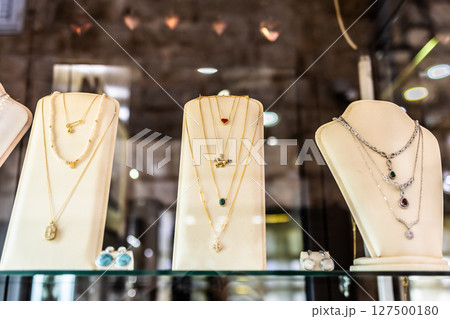 Elegant necklaces displayed on velvet stands. Jewelry arrangement, fashion showcase, and luxury retail style. 127500180