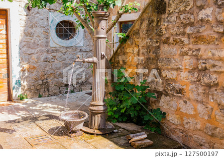Vintage street fountain with flowing water. Urban heritage, public utility, and Mediterranean charm. Vintage street fountain with flowing water. Urban heritage, public utility, and Mediterranean charm. 127500197