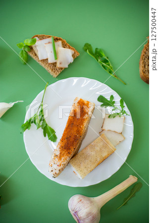Traditional Ukrainian dish with lard and greens on a green background 127500447