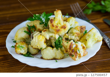 Appetizing fried cauliflower on a dark kitchen surface Appetizing fried cauliflower on a dark kitchen surface 127500457