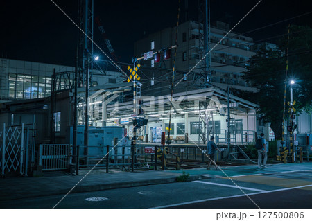 夜の小田急相模原駅　踏切を渡る歩行者 127500806