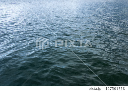 Water background of lake Traunsee in the Alps. Colorful texture of reflections of clear mountain lake Water background of lake Traunsee in the Alps. Colorful texture of reflections of clear mountain lake 127501758
