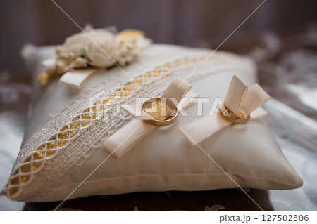 Elegant Wedding Rings on Silk Pillow with Floral Accents: Gold Bands, Cream Lace, Romantic Ceremony Symbolism, Bridal Accessories, Soft Focus Elegant Wedding Rings on Silk Pillow with Floral Accents: Gold Bands, Cream Lace, Romantic Ceremony Symbolism, Bridal Accessories, Soft Focus 127502306