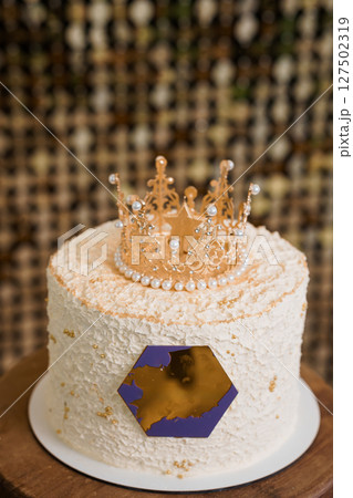 Golden Crown Adorned Peach Birthday Cake with Gold Accents on Wooden Stand. Regal Celebration Dessert Decor Golden Crown Adorned Peach Birthday Cake with Gold Accents on Wooden Stand. Regal Celebration Dessert Decor 127502319