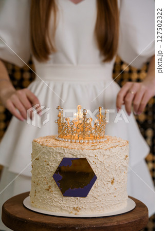 Elegant Woman With Crown Cake. Golden Birthday Celebration. White Dress. Textured Frosting. Glamorous Party Theme. Luxury Dessert. Festive Atmosphere Elegant Woman With Crown Cake. Golden Birthday Celebration. White Dress. Textured Frosting. Glamorous Party Theme. Luxury Dessert. Festive Atmosphere 127502322