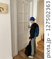 Boy stands in front of a hostel room door, opening it while holding his luggage. Essence of hostel living and the adventures that await 127502363