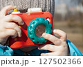 Little photographer with toy camera. Child playing outdoors 127502366