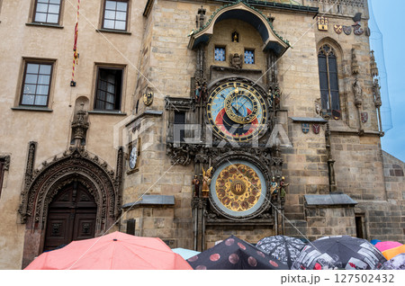Prague, Czech Republic, August 5, 2023. The astronomical clock is one of the main attractions of the old town. On a rainy day, people with umbrellas crowded to see it. Travel destinations. Prague, Czech Republic, August 5, 2023. The astronomical clock is one of the main attractions of the old town. On a rainy day, people with umbrellas crowded to see it. Travel destinations. 127502432