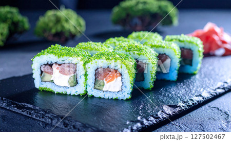Bioluminescent sushi rolls glowing on dark stone platter with wasabi forest. Generated Image Bioluminescent sushi rolls glowing on dark stone platter with wasabi forest. Generated Image 127502467