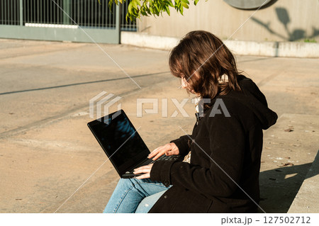 Young woman seen from above working outdoors Young woman seen from above working outdoors 127502712