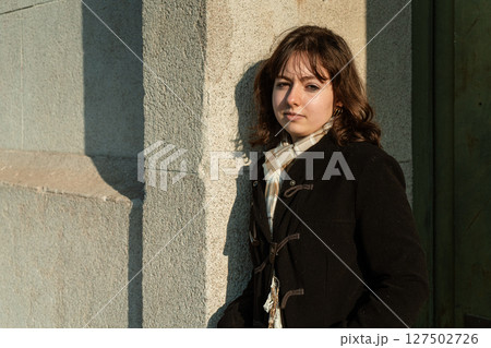 Portrait of woman with stern expression against urban background 127502726