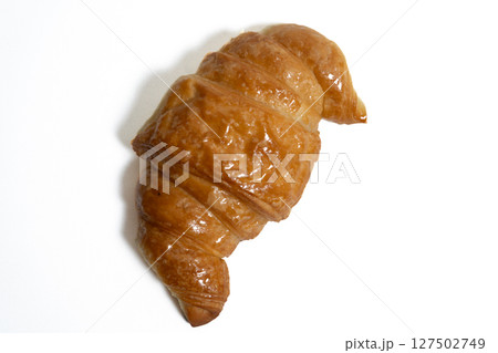 Golden croissant isolated on white background food photography 127502749