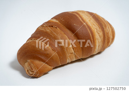 Perfectly baked croissant isolated with natural lighting 127502750