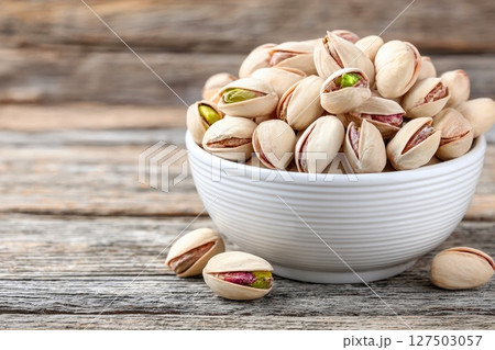 White Bowl Filled with Pistachios on Wooden Surface White Bowl Filled with Pistachios on Wooden Surface 127503057