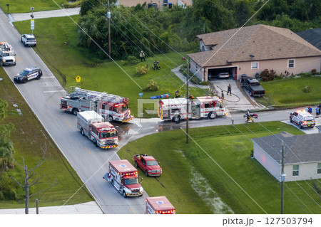 Firefighter trucks at fire alarm scene of suburban house. First responders at potential fire hazard at Florida home Firefighter trucks at fire alarm scene of suburban house. First responders at potential fire hazard at Florida home 127503794