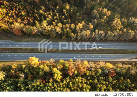 Elevated view of freeway road lanes between autumn mountain hills. Interstate transportation infrastructure in USA Elevated view of freeway road lanes between autumn mountain hills. Interstate transportation infrastructure in USA 127503809