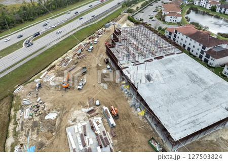 Development of commercial housing in USA. Construction works on monolithic frame. Large building site with scattered workers and equipment. Real estate market 127503824