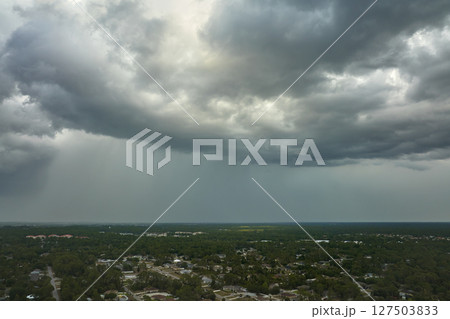 Dark stormy clouds forming on gloomy sky before heavy rainfall over suburban town area Dark stormy clouds forming on gloomy sky before heavy rainfall over suburban town area 127503833