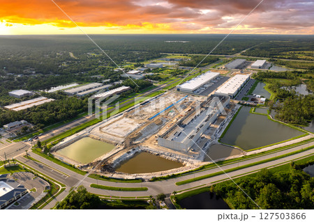 Construction site of logistic center with assembling of concrete and metal frame walls. Aerial view of large development area of commercial structure 127503866