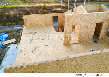 Construction of new and modern modular house. Walls made from composite wooden sip panels with styrofoam insulation inside. Building new frame of energy efficient home concept. Construction of new and modern modular house. Walls made from composite wooden sip panels with styrofoam insulation inside. Building new frame of energy efficient home concept. 127503869