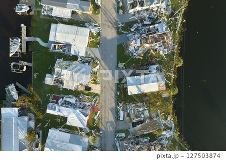Consequences of natural disaster in Florida, USA. Aerial view of heavily damaged by hurricane Ian houses in mobile home residential area 127503874