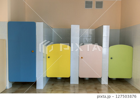 Colorful toilet doors in elementary school bathroom interior. Colorful toilet doors in elementary school bathroom interior. 127503876